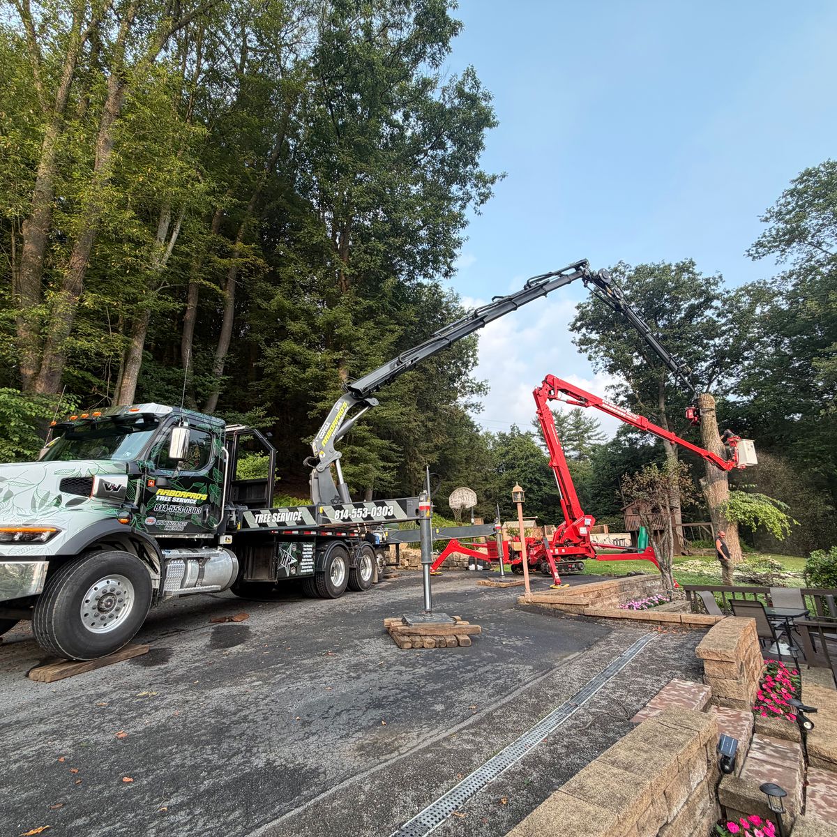 Arbor Pro’s crane truck and spider lift set up on a residential driveway